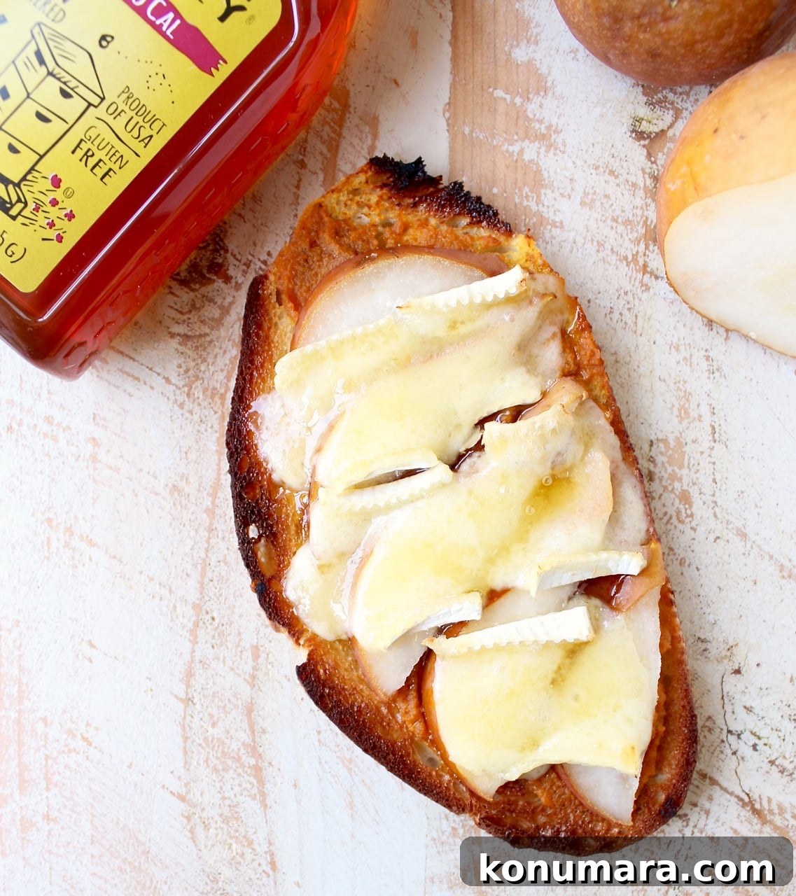 a slice of pumpkin toast topped with melted brie cheese and sliced apples