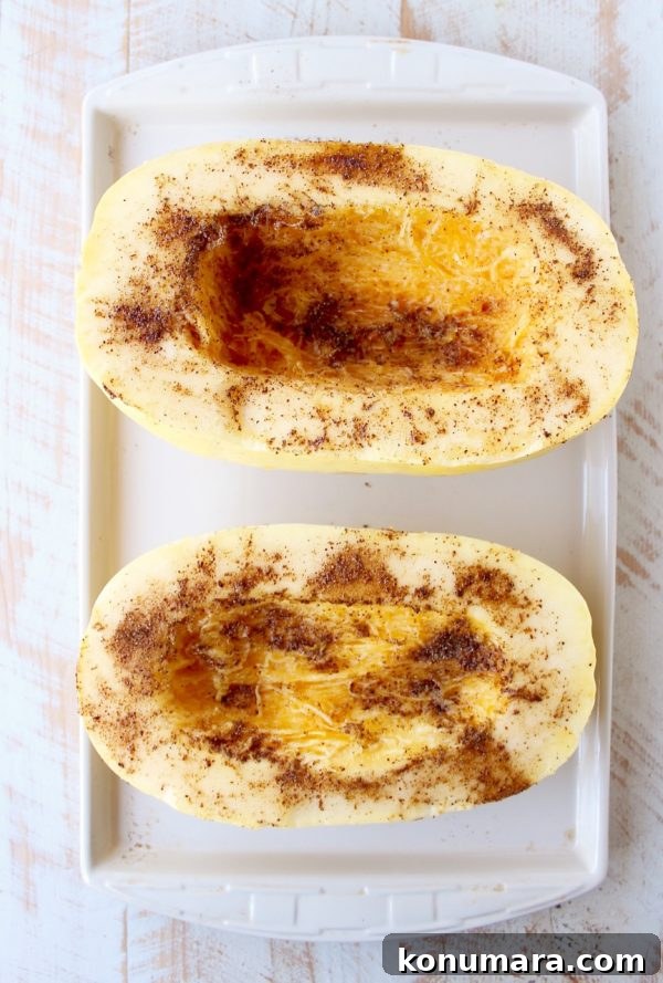 seasoned spaghetti squash cut in half on baking sheet