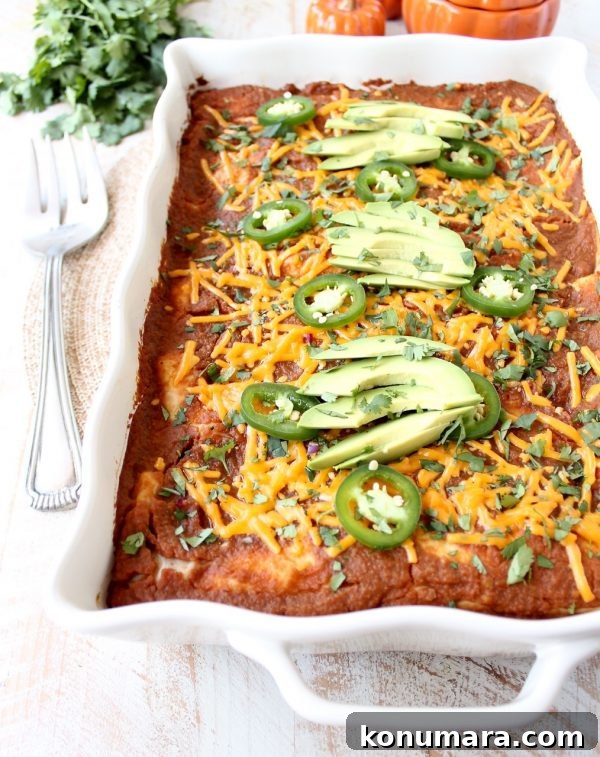 Baked pumpkin enchiladas topped with melted cheddar and jalapeños