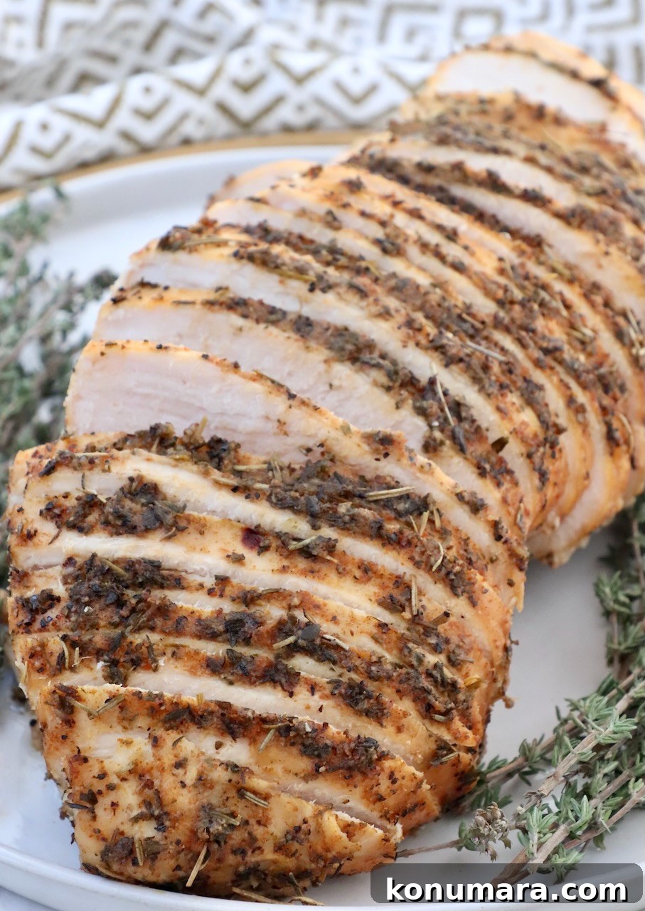 Juicy Slow-Cooker Turkey Breast Recipe 2 sliced turkey breast on a plate with fresh thyme