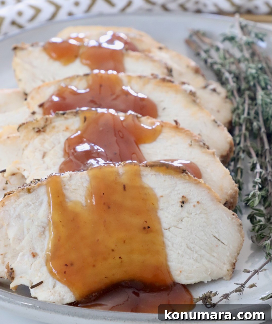 Juicy Slow-Cooker Turkey Breast Recipe 10 slices of turkey on a plate with a maple glaze drizzled over the turkey
