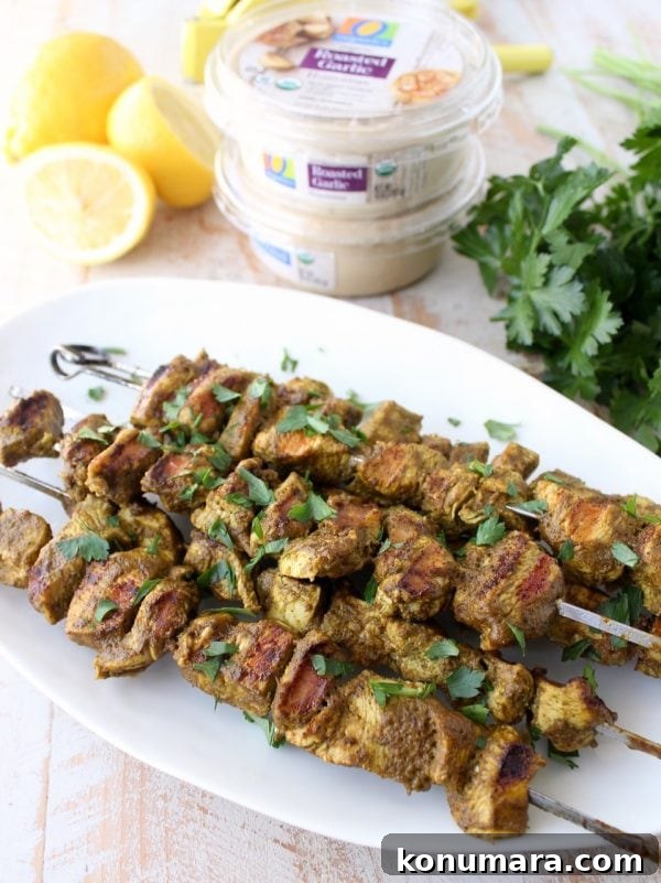 Grilled Mediterranean Chicken Skewers with Lemon and Herbs 6 Close-up of a skewer dipped in hummus