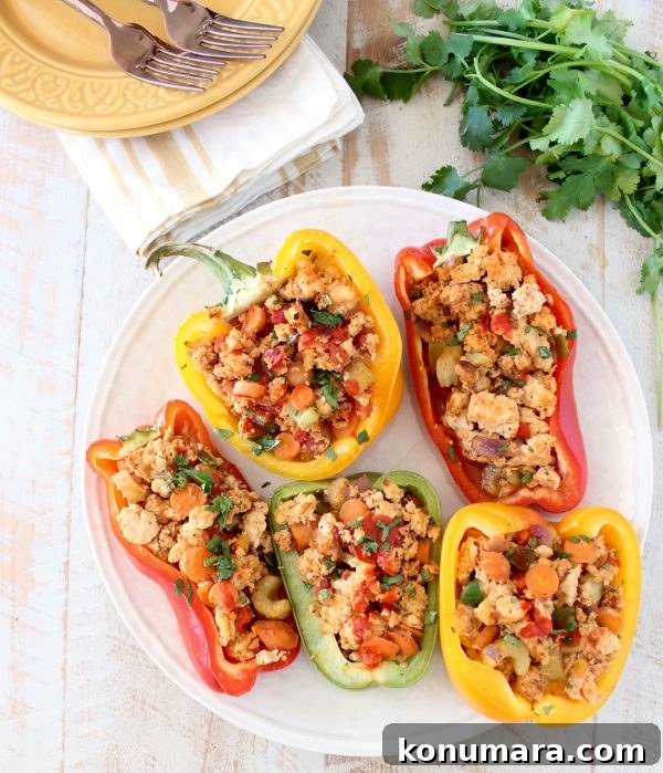 Overhead shot of buffalo chicken stuffed peppers on white plate with cilantro on the side