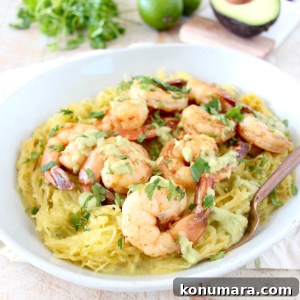 Whole30 dish of roasted spaghetti squash topped with cilantro lime shrimp and green chili avocado sauce