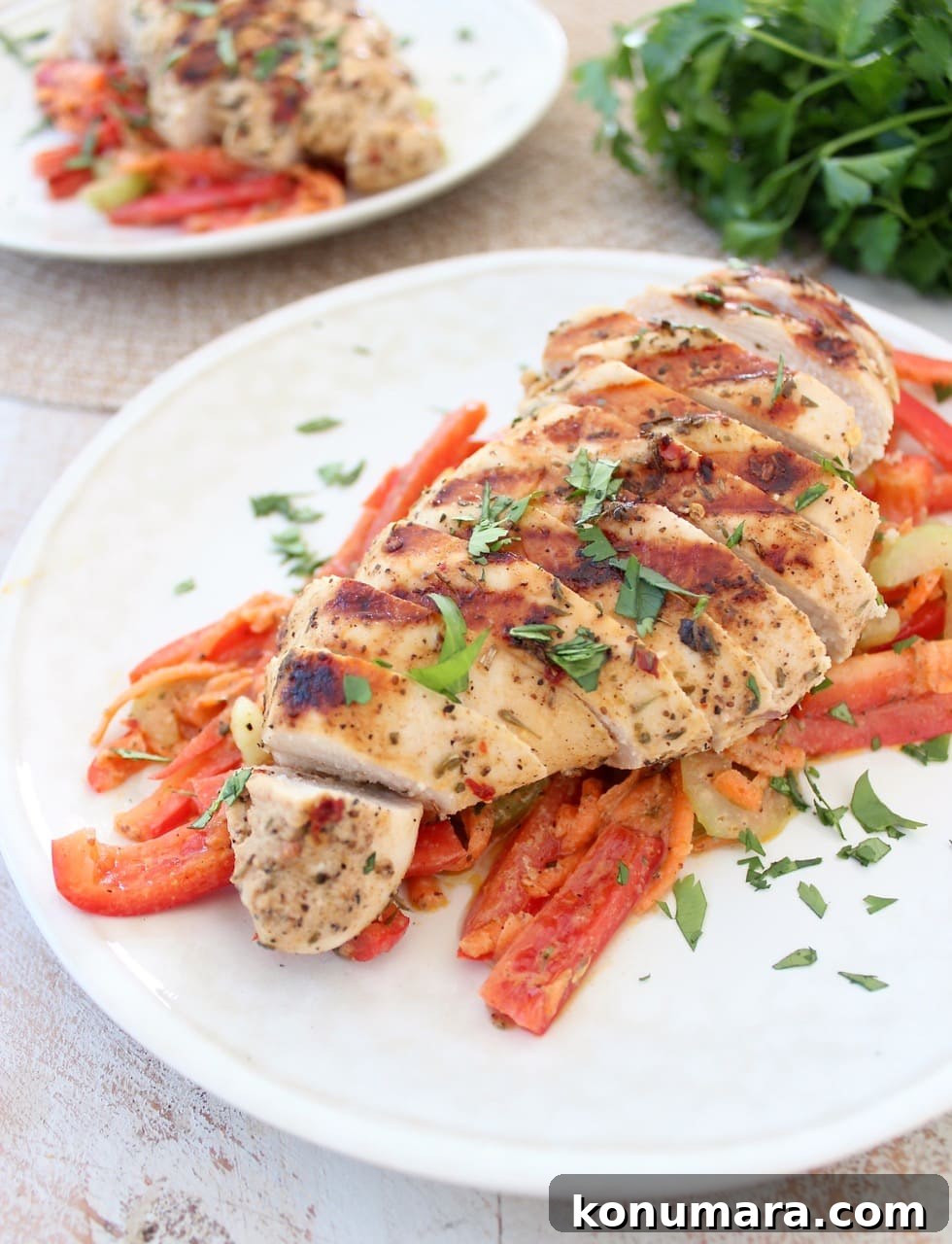 sliced grilled chicken on top of bell pepper slaw on white plate
