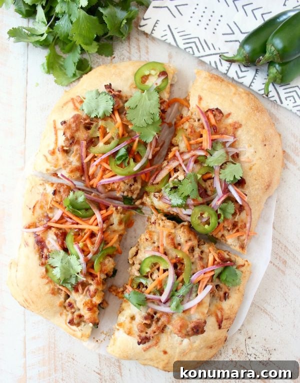 Banh Mi Pizza topped with sesame-ginger ground pork, carrots, jalapeños, cilantro and Sriracha