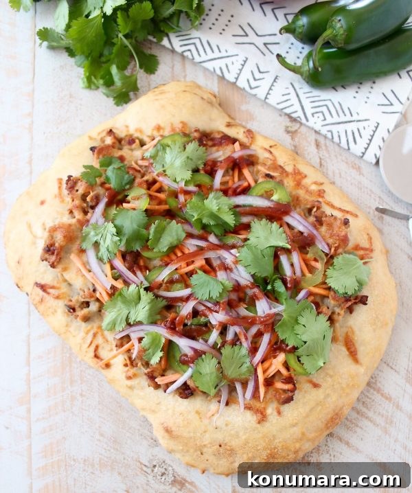 Banh Mi Pizza close-up showing fresh toppings and sesame-ginger sauce