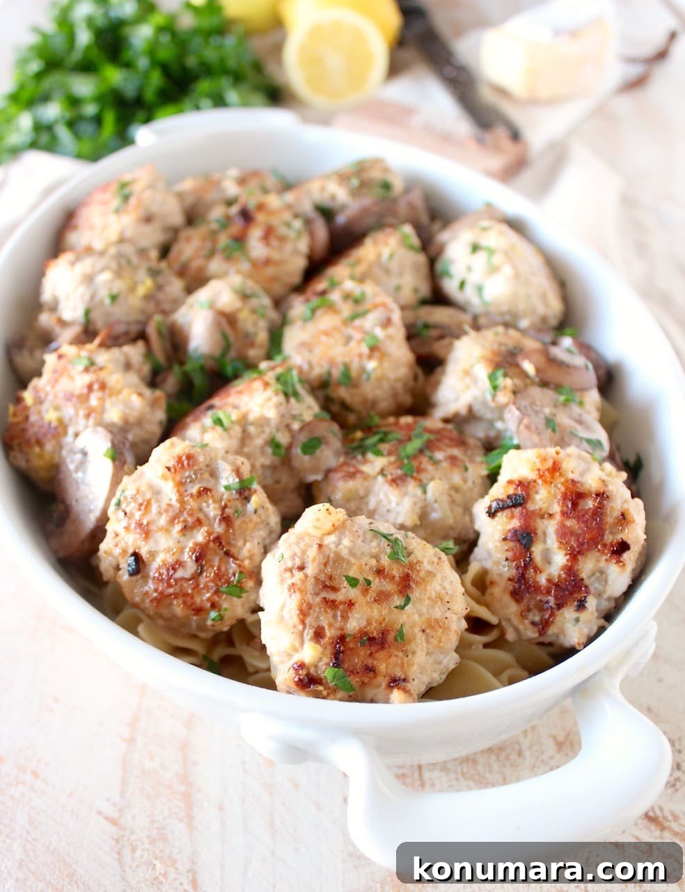 cooked meatballs in a casserole dish with cooked noodles