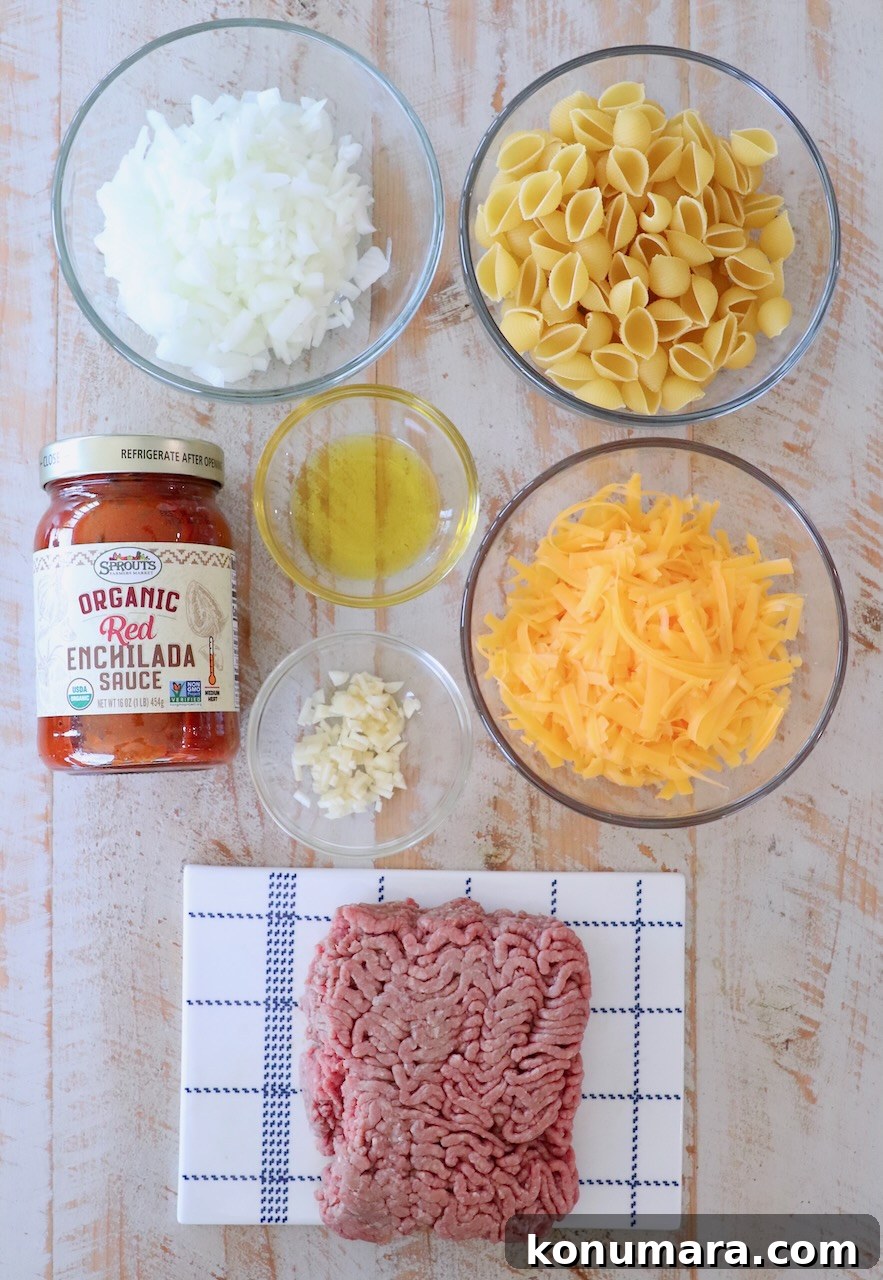 ingredients for enchilada pasta on white wood board