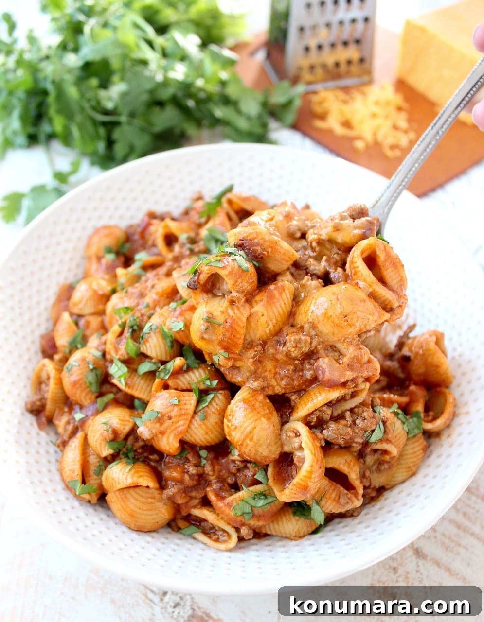 serving spoon scooping Enchilada Pasta from a large bowl