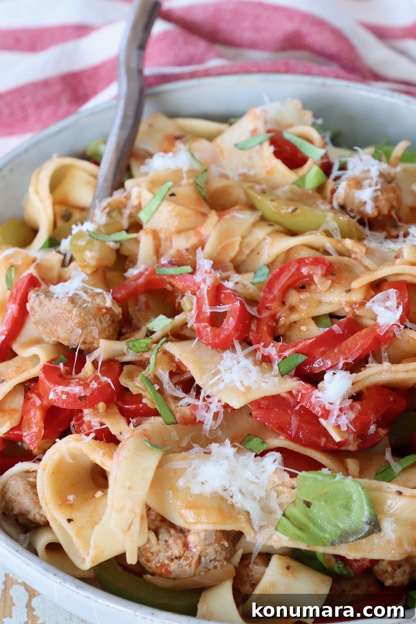 cooked pasta in bowl with bell peppers and basil leaves
