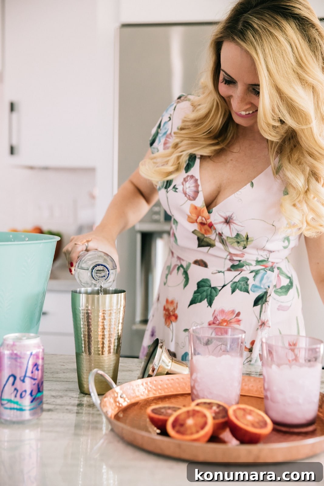 Whitney Bond making cocktails in kitchen with blood oranges, vodka and la croix