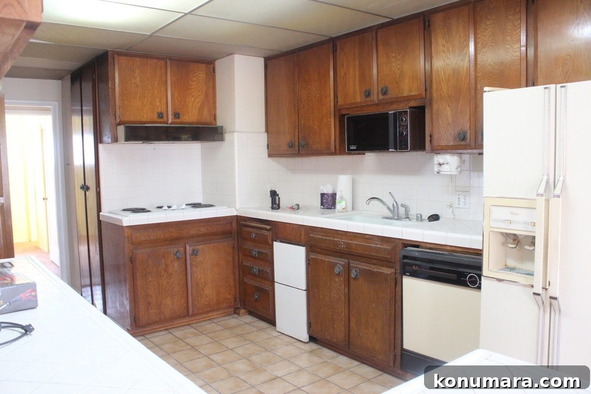 Old kitchen with brown wood cabinets and old appliances