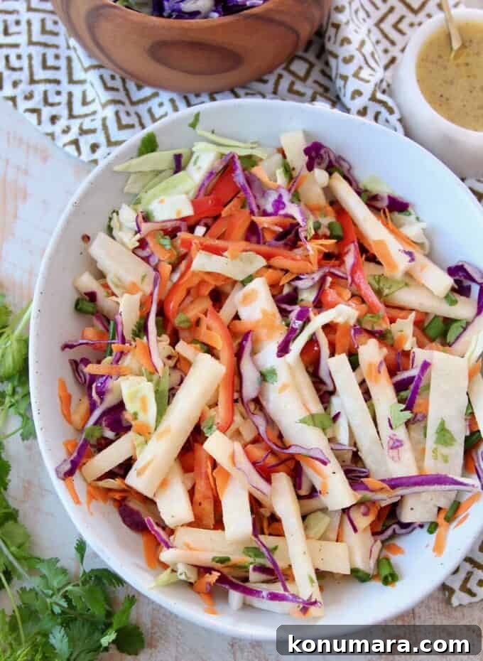 Crisp Jicama Slaw with Lime and Cilantro 5 jicama slaw in bowl with slaw dressing on the side