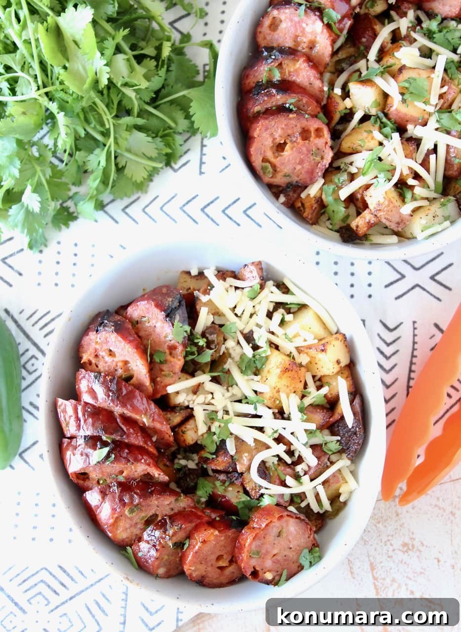 Grilled Jalapeno Cheddar Sausage in a bowl with Grilled Potatoes, Peppers and Shredded Cheddar Cheese