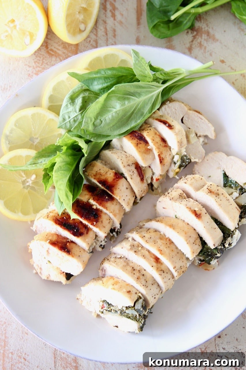 Sliced Spinach Artichoke Stuffed Chicken Breasts with Lemon Slices and Fresh Basil