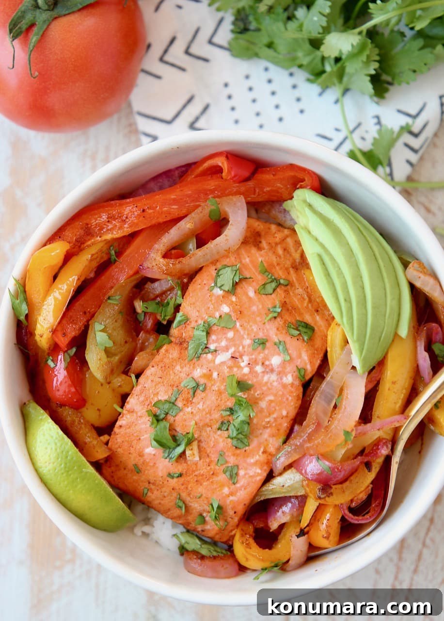 Baked Salmon Fajitas with Bell Peppers and Onions, Sliced Avocado and Lime Wedge in Bowl with Rice