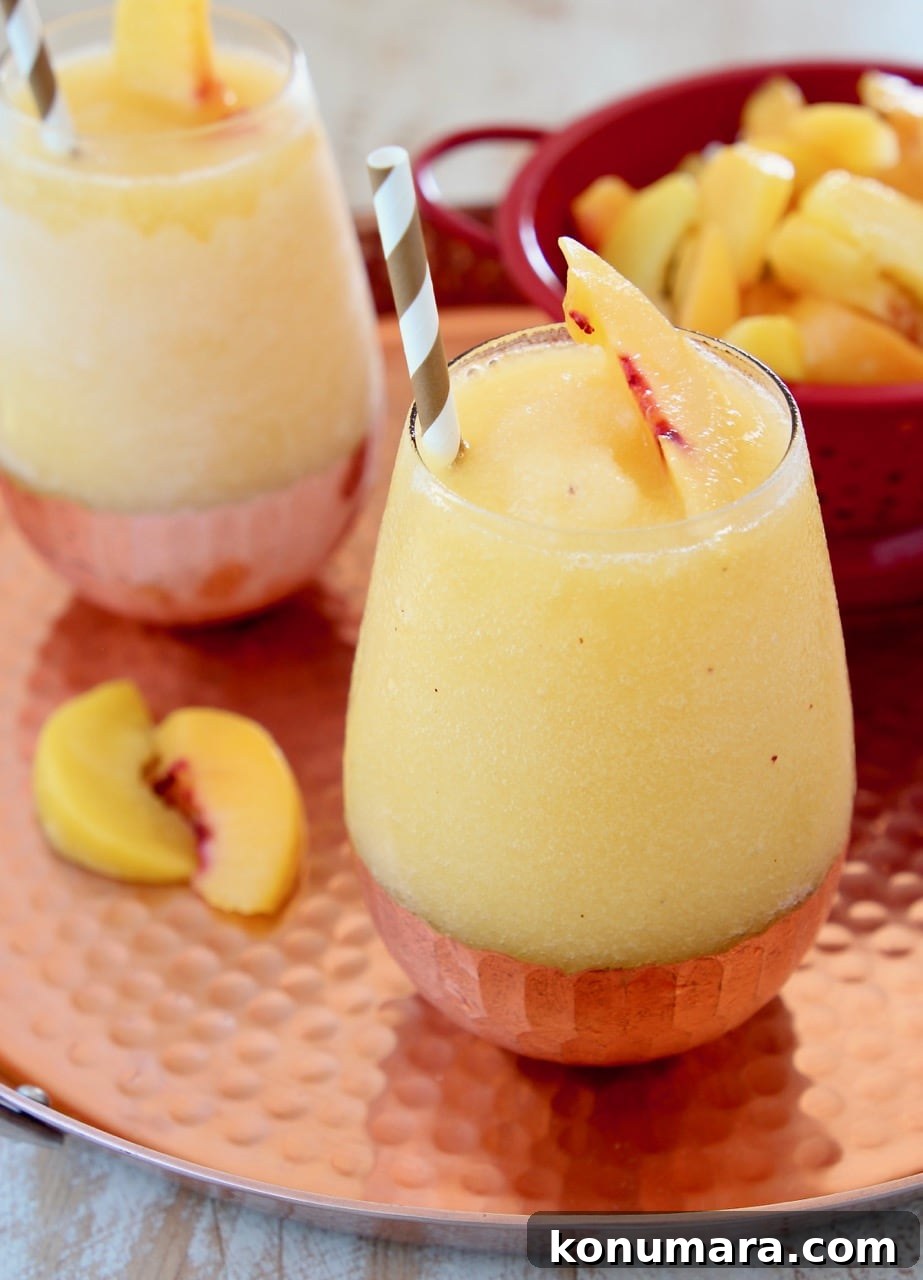 Frozen Peach Sangria Recipe - Refreshing Summer Cocktail 5 Frozen Peach Sangria with Fresh Peaches and Gold and White Striped Straw on Copper Tray
