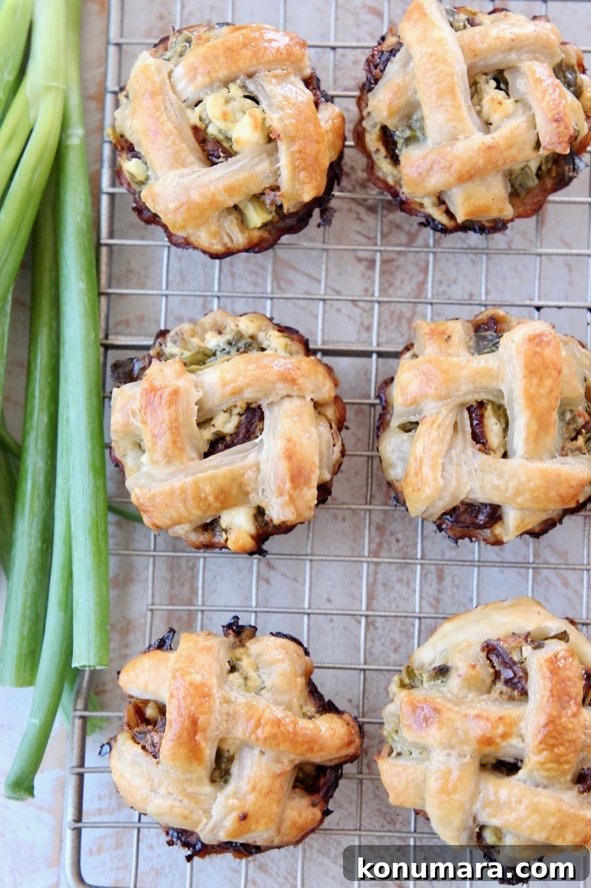 Mini Spinach and Feta Pies 6 Spinach Feta Mini Pies with Braided Puff Pastry Crust on Wire Baking Rack with Green Onions