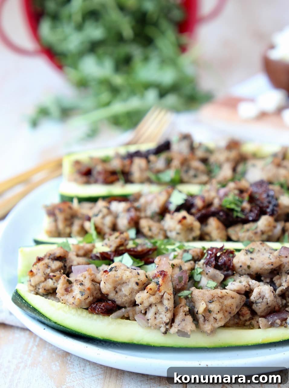 Greek Turkey-Stuffed Zucchini Boats with Feta 2 Greek Turkey Stuffed Zucchini Boats on white plate with gold forks in background
