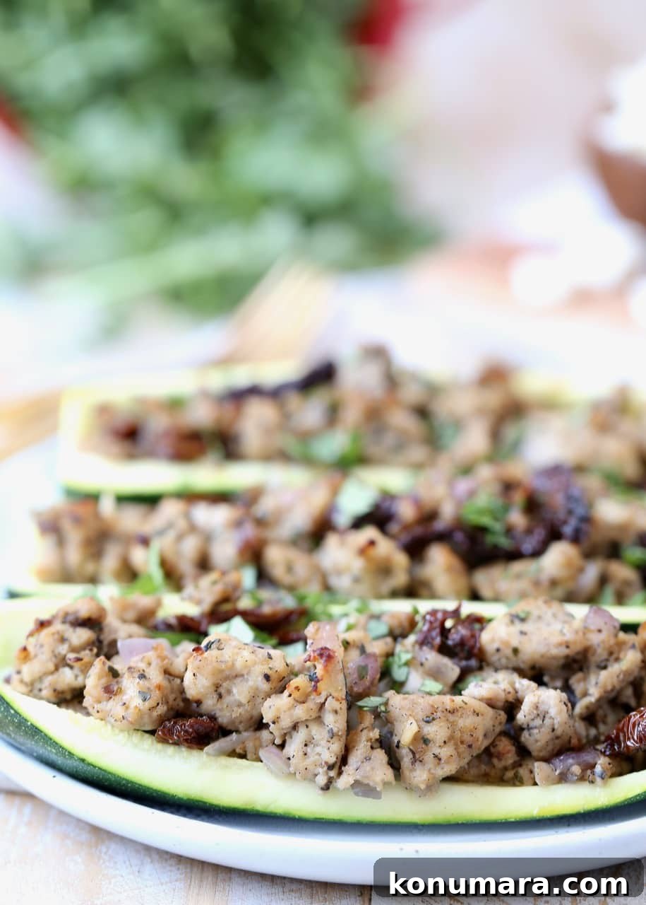 Greek Turkey-Stuffed Zucchini Boats with Feta 4 Ground Turkey and Sun Dried Tomatoes in zucchini boats on white plate