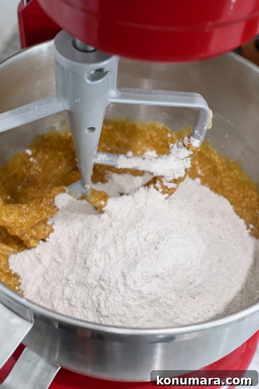 Moist Pumpkin Cupcakes with Tangy Cream Cheese Frosting 7 flour mixture in stand mixer with pumpkin cupcake batter
