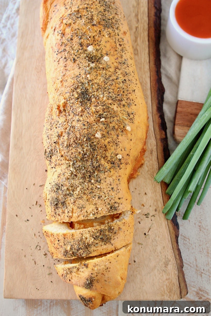 Cheesy Buffalo Chicken Pizza Bread 3 Buffalo cheesy pizza bread roll, sliced on wood cutting board with green onions