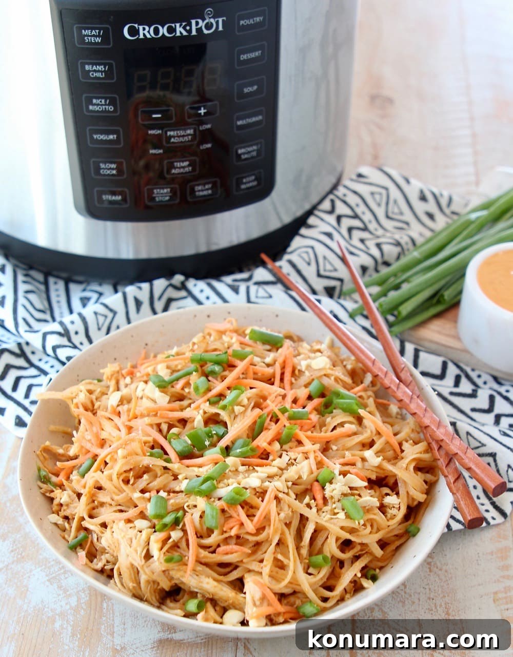 Thai peanut chicken noodles in bowl with chopsticks and Crock Pot Express Crock Multi Cooker
