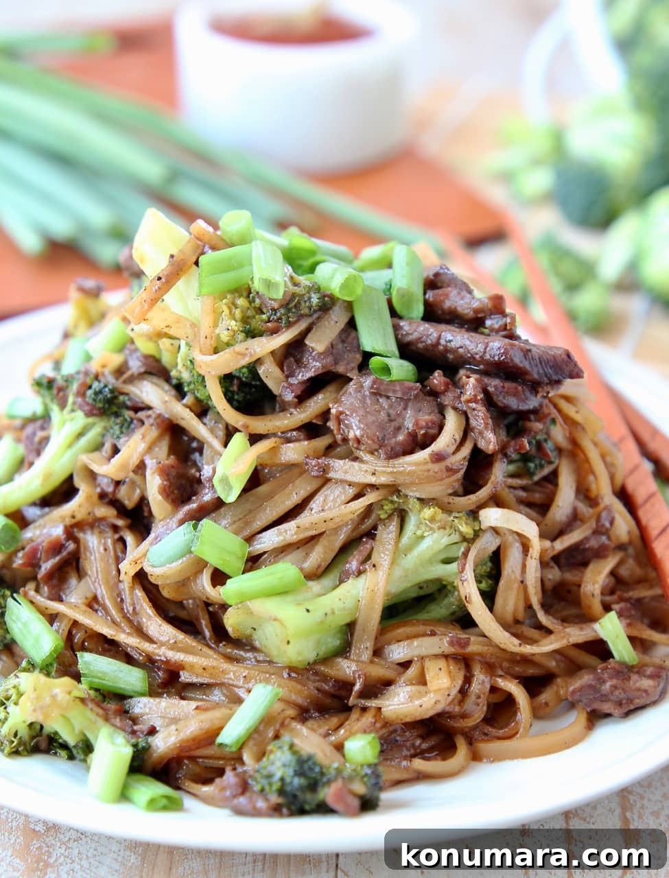 Slow Cooker Black Pepper Beef with Broccoli Recipe 2 Black Pepper Beef and Broccoli with rice noodles and scallions on plate with chopsticks