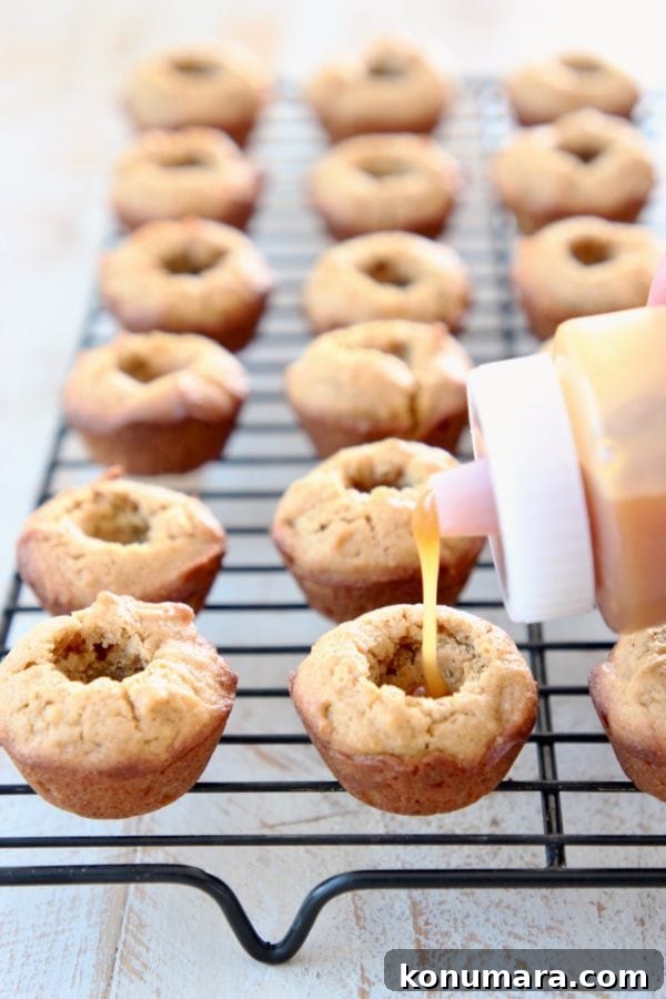 Salted Caramel Pumpkin Cookie Cups 6 Plastic squeeze bottle with salted caramel sauce, filling mini pumpkin cookie cups on black wire baking rack