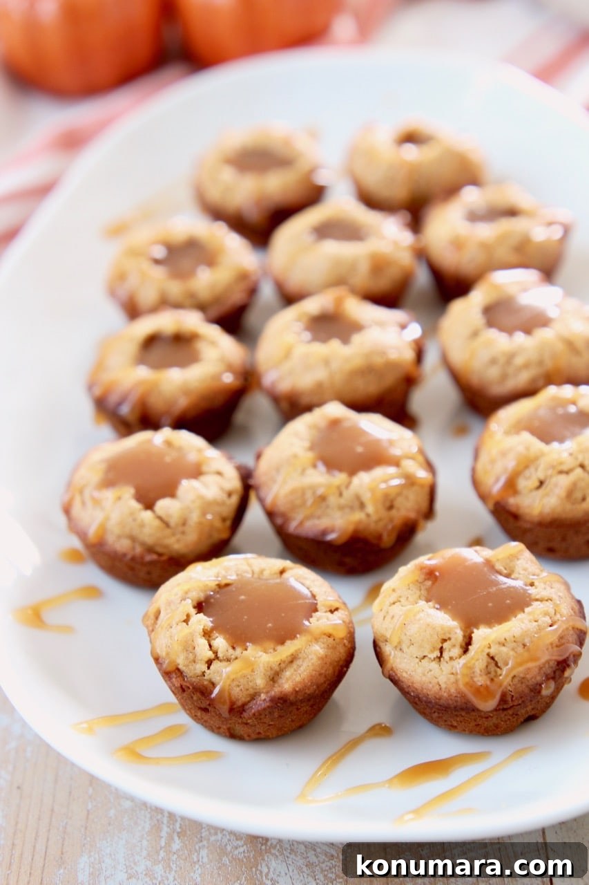 Salted Caramel Pumpkin Cookie Cups 8 Mini pumpkin cookie cups filled with salted caramel sauce on white plate with orange striped towel