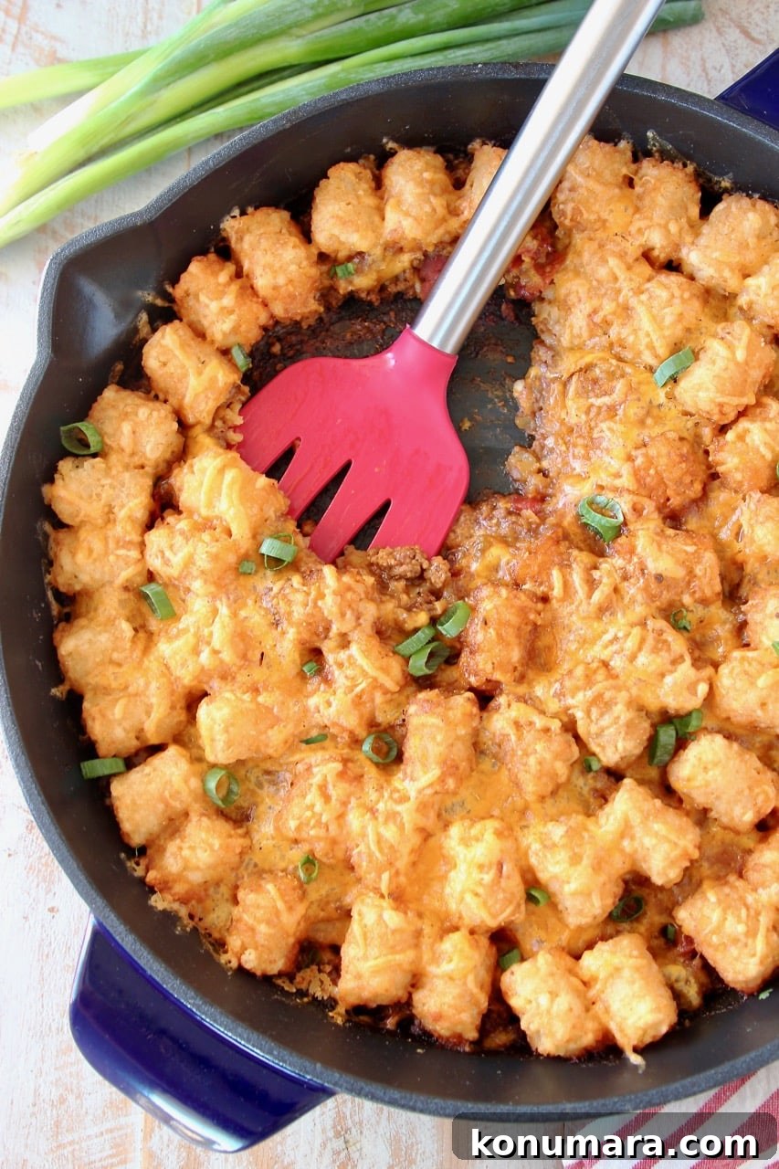 Buffalo Cheeseburger Tater Tot Casserole Recipe 3 Tater Tot Casserole in cast iron skillet with red spatula and green onions