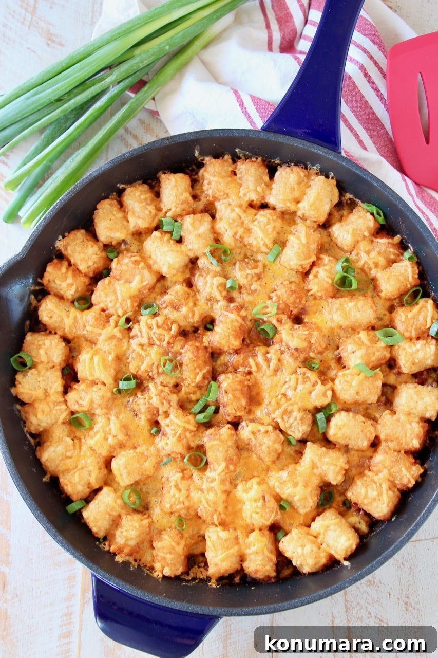 Buffalo Cheeseburger Tater Tot Casserole Recipe 5 The best Tater Tot Casserole with ground beef and cheese in skillet with green onions and red striped towel