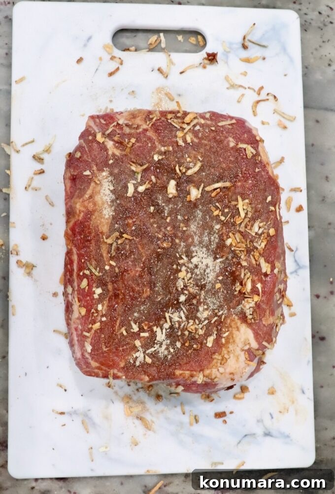 Savory French Onion Pot Roast with Caramelized Onions 5 seasoned raw beef roast on a white cutting board