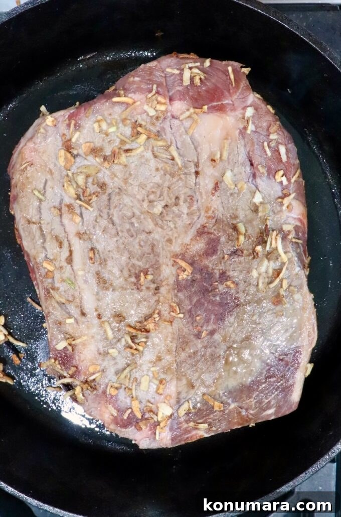 Savory French Onion Pot Roast with Caramelized Onions 8 seasoned, seared beef roast in a cast iron skillet