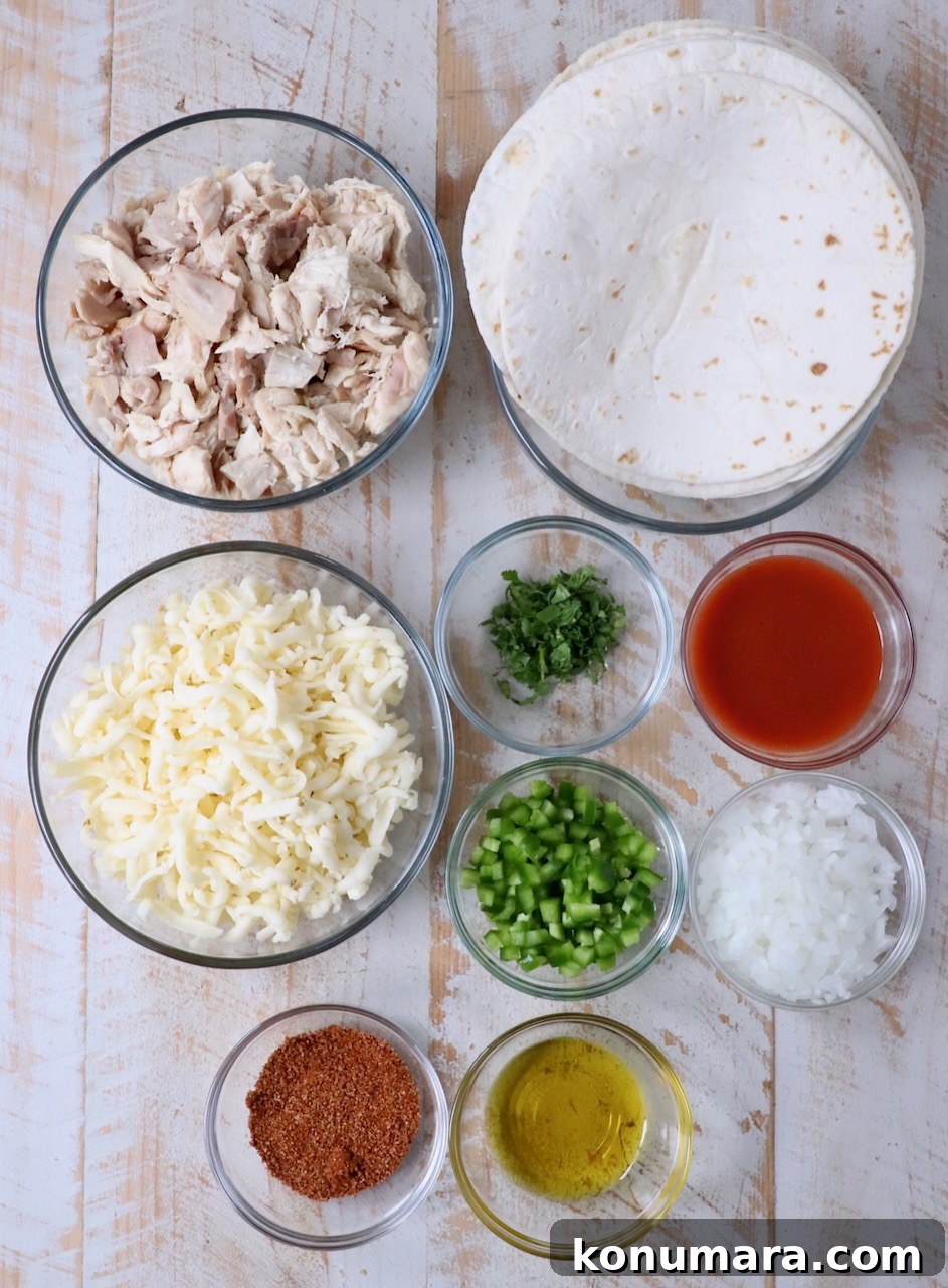 ingredients for buffalo chicken taquitos on a white wood board