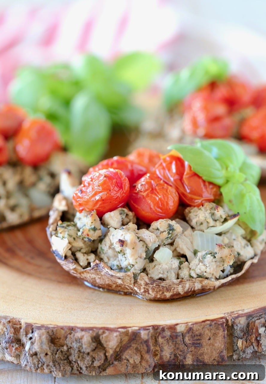 Whole30 Italian Stuffed Portobello Mushrooms Recipe 4 Stuffed portobello mushrooms with ground turkey, cherry tomatoes, fresh basil, on a wood cutting board