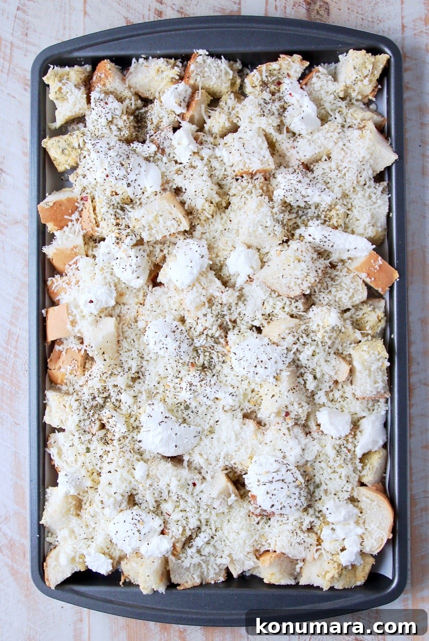 Cheesy Garlic Bread Nachos Recipe 4 Garlic bread covered in cheese on a baking sheet