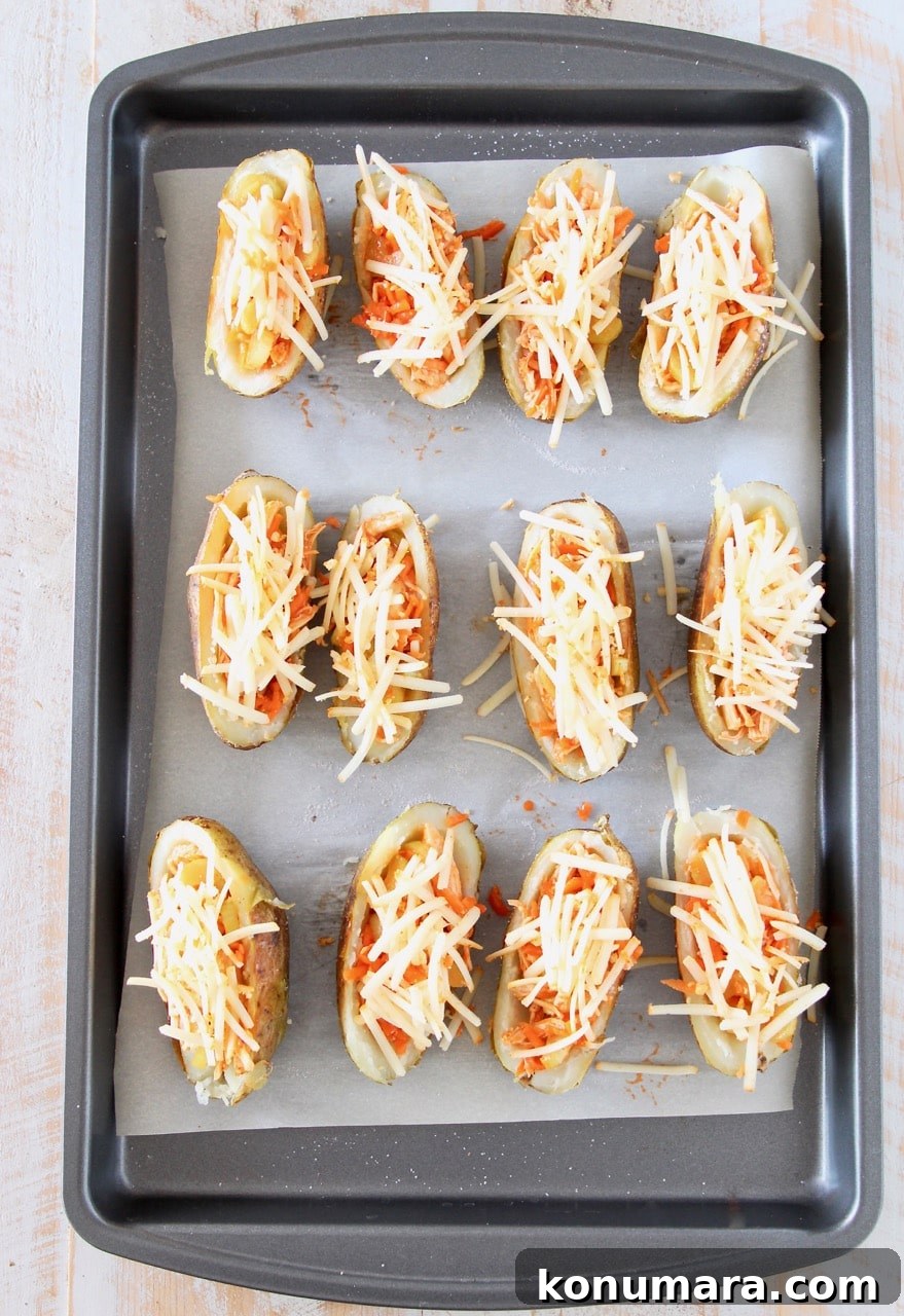 Crispy Buffalo Chicken Potato Skins 4 Potato skins filled with buffalo chicken and shredded cheddar cheese on baking sheet