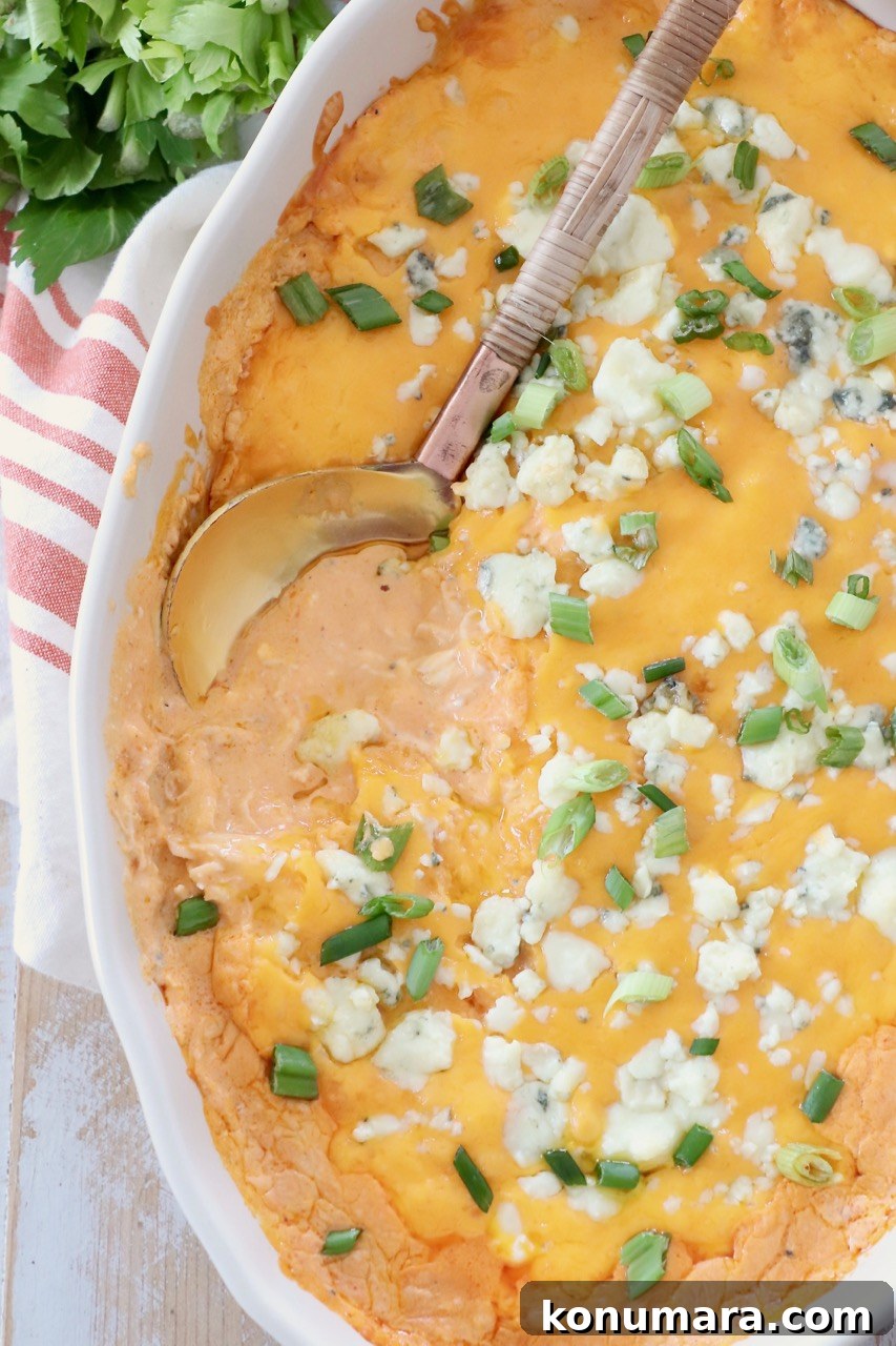 buffalo chicken dip in baking dish with serving spoon
