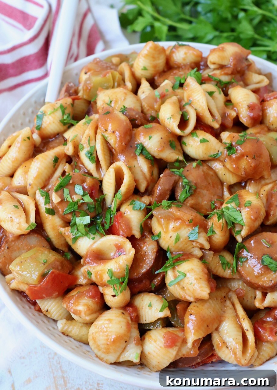 cajun pasta with sausage and peppers in a large bowl with a fork