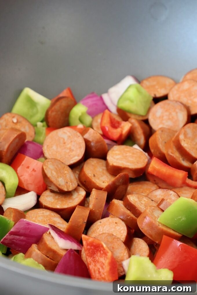 sliced sausage, diced bell peppers and onions in large skillet