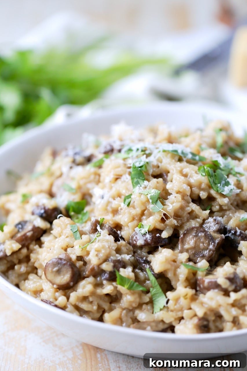 Instant pot risotto with mushrooms and parmesan cheese in bowl with spoon