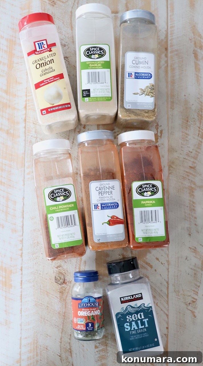 Homemade Fajita Seasoning Mix Recipe 3 spices for fajita seasoning in plastic containers on white wood board