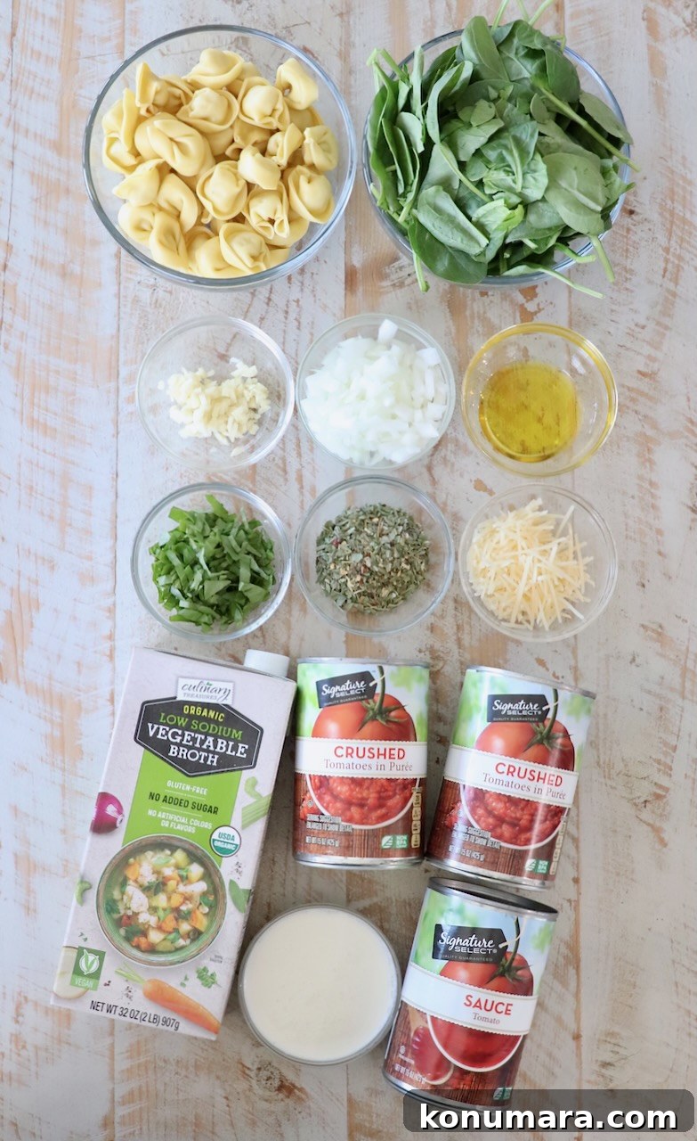 ingredients for tortellini soup on white wood board
