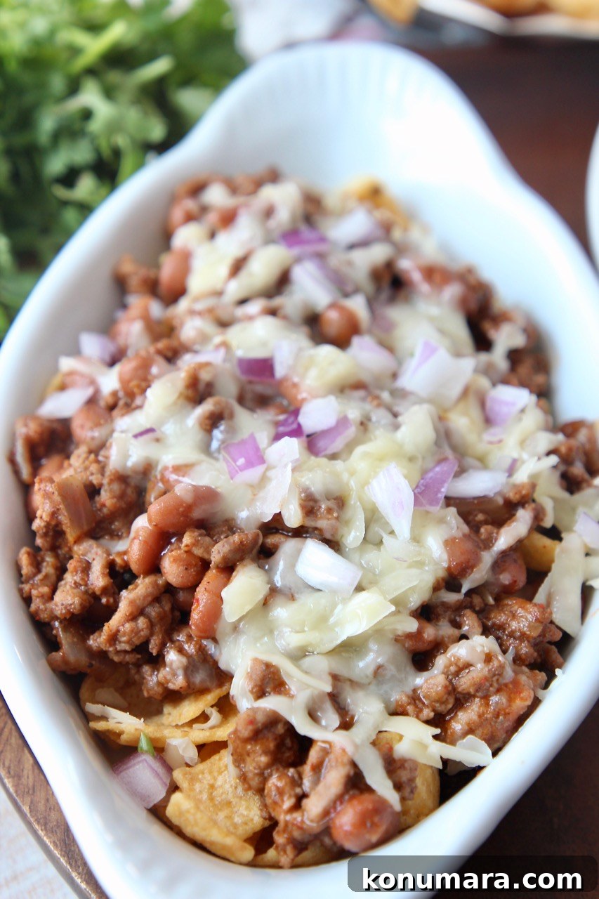Classic Frito Chili Pie Recipe with Cheesy Corn Chip Topping 2 frito chili pie in white baking dish