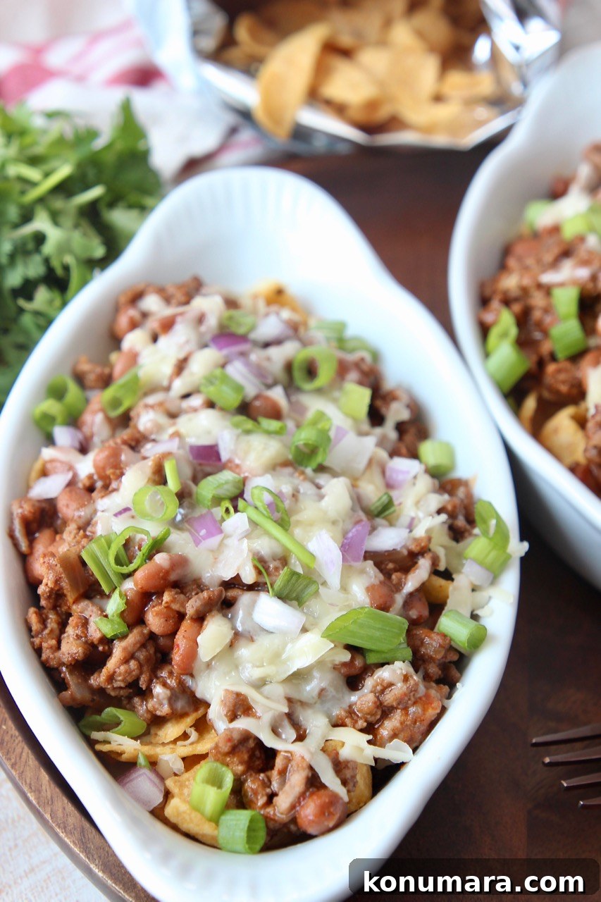 Classic Frito Chili Pie Recipe with Cheesy Corn Chip Topping 6 frito chili pie in white serving dish