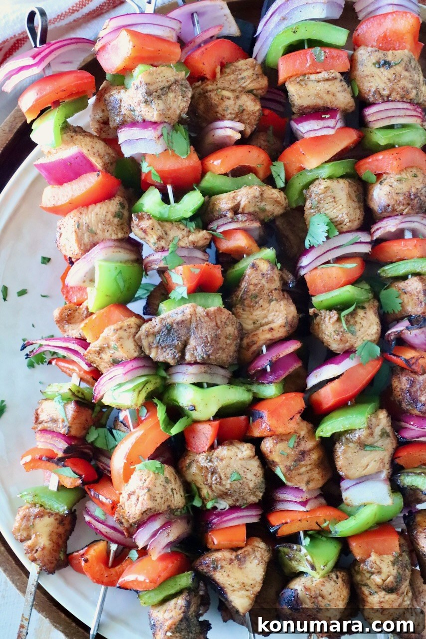 fajita chicken skewers stacked up on a plate