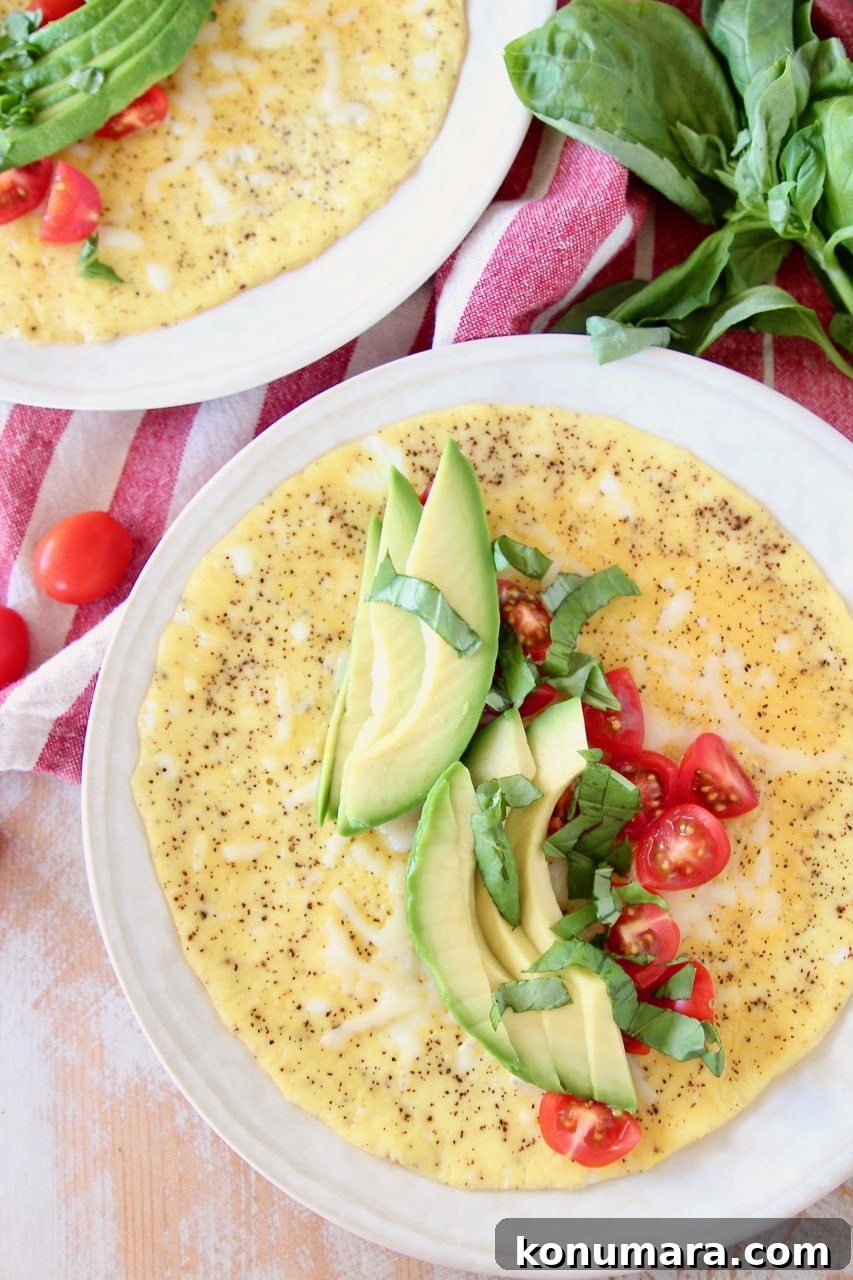 Omelette topped with fresh sliced avocado, tomatoes and basil