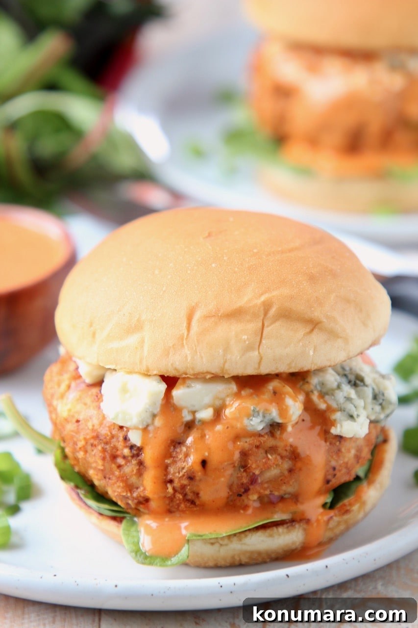 Spicy Buffalo Chicken Burgers with Blue Cheese Slaw 5 Buffalo chicken burger on a bun with blue cheese crumbles